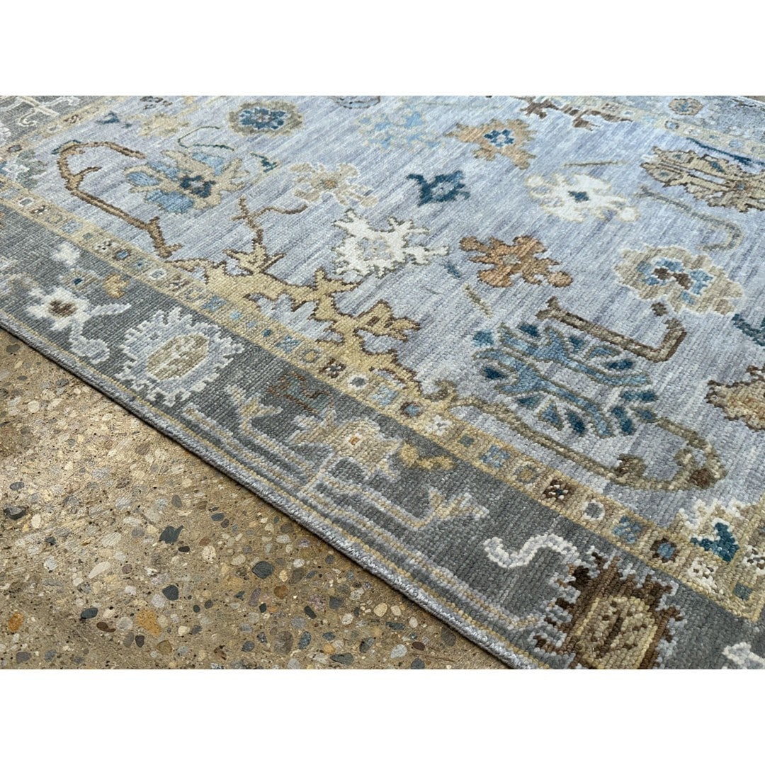 Close view of the blue field and floral border of Opulent Oushak